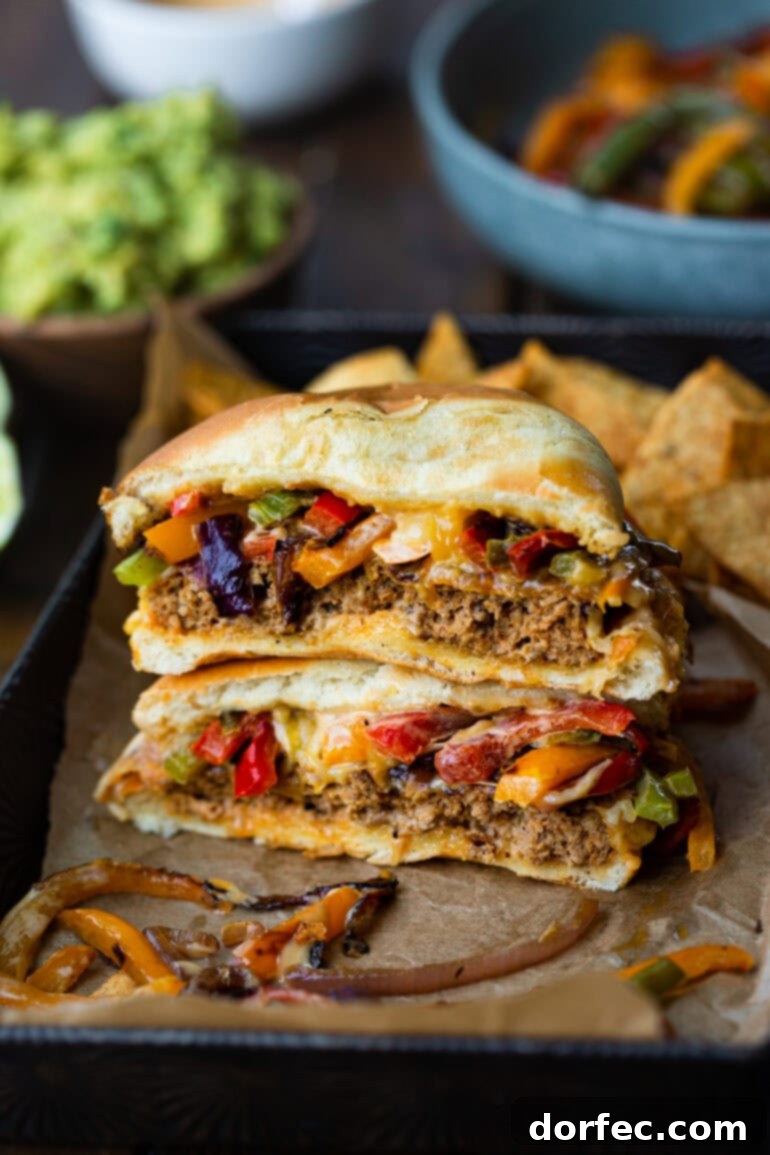 Sizzling Mexican Fajita Burgers 7 A single fajita turkey burger, cut in half and stacked to showcase the layers of flavorful patty, sautéed onions, and bell peppers, demonstrating its juicy, vibrant interior.