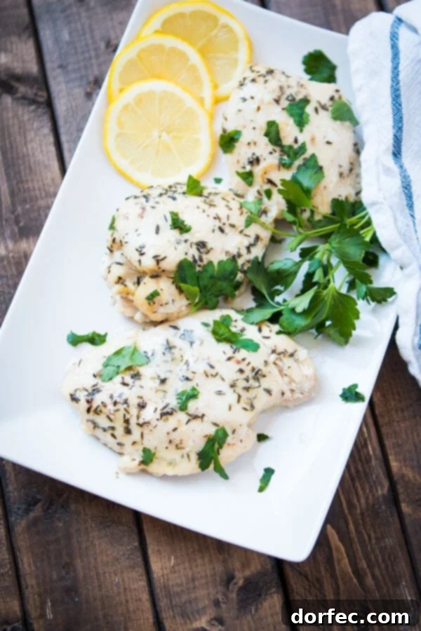 Tender chicken breasts marinating in lemon and butter sauce in the slow cooker.