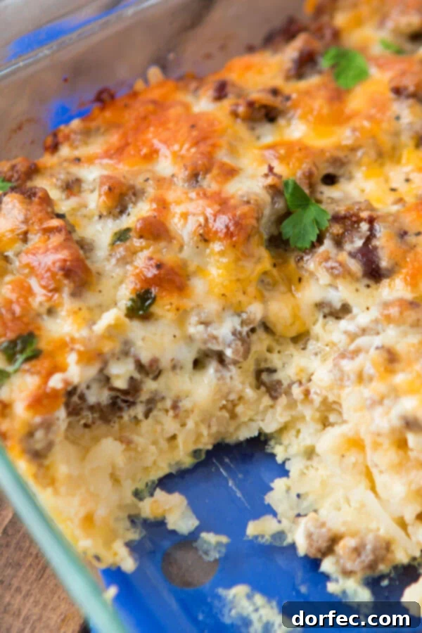 Delicious cheesy hash brown sausage breakfast casserole, a perfect make-ahead breakfast idea. cheesy hash brown sausage breakfast casserole in glass baking dish, ready to be served