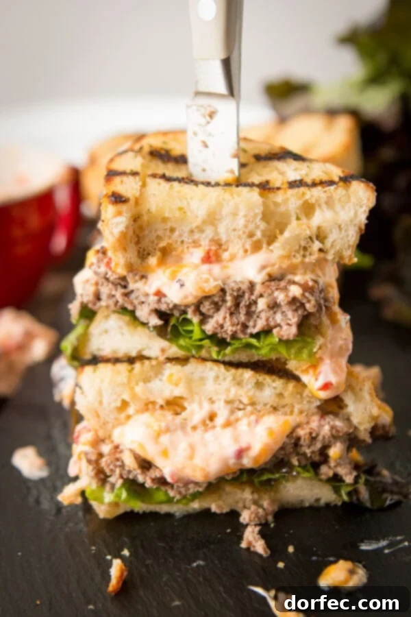 A beautifully presented Southern Pimento Cheeseburger, showing the rich pimento cheese and the inviting grill marks on the Texas Toast.