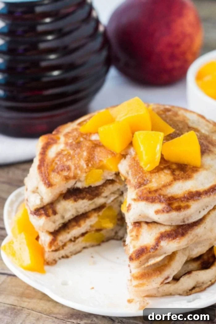 Sliced Brown Sugar Cinnamon Peach Pancakes with Maple Syrup A stack of beautifully sliced brown sugar cinnamon pancakes, adorned with juicy peach slices and a drizzle of maple syrup, capturing the inviting texture and rich color of a perfect breakfast.