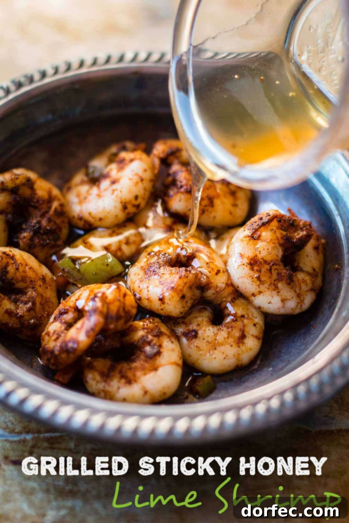 Grilled Sticky Honey Lime Shrimp on a plate, garnished with fresh cilantro and lime