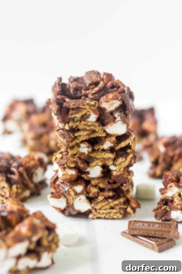 Learn how to make no bake s'mores bars at home! This simple recipe calls for 4 ingredients and takes under 15 minutes to come together. This summer dessert recipe is so yummy and easy you'll want to make it every week. Hershey's chocolate, mini marshmallows, Golden Grahams