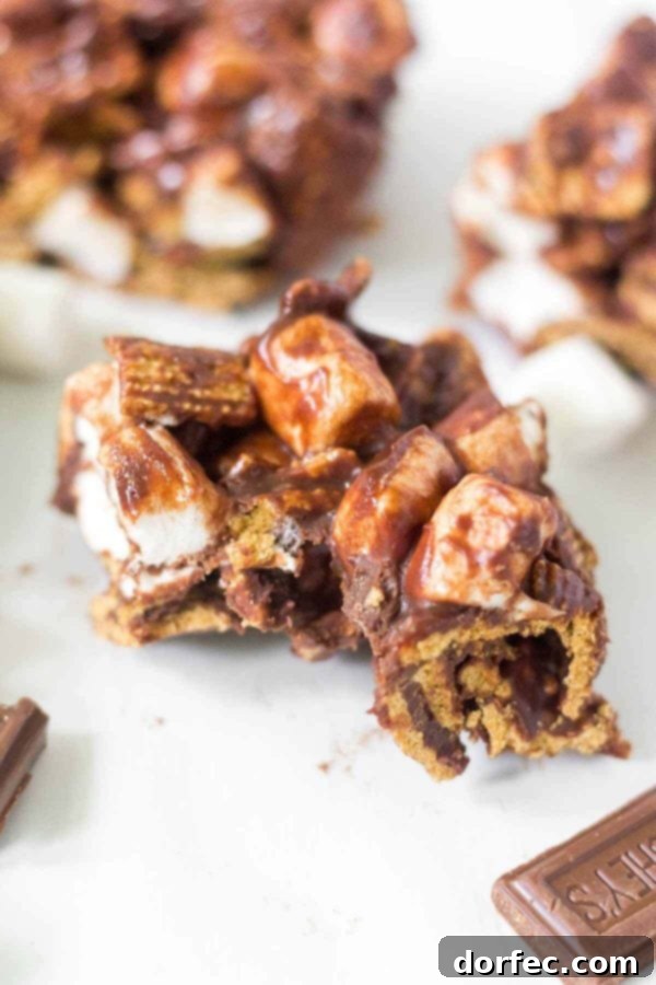 Learn how to make no bake s'mores bars at home! This simple recipe calls for 4 ingredients and takes under 15 minutes to come together. This summer dessert recipe is so yummy and easy you'll want to make it every week. Hershey's chocolate, mini marshmallows, Golden Grahams