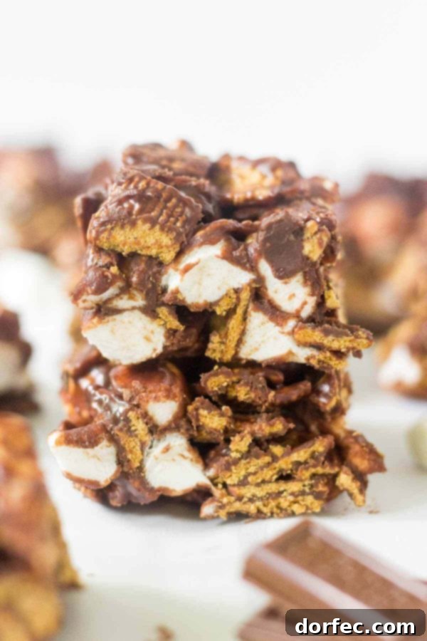 Learn how to make no bake s'mores bars at home! This simple recipe calls for 4 ingredients and takes under 15 minutes to come together. This summer dessert recipe is so yummy and easy you'll want to make it every week. Hershey's chocolate, mini marshmallows, Golden Grahams