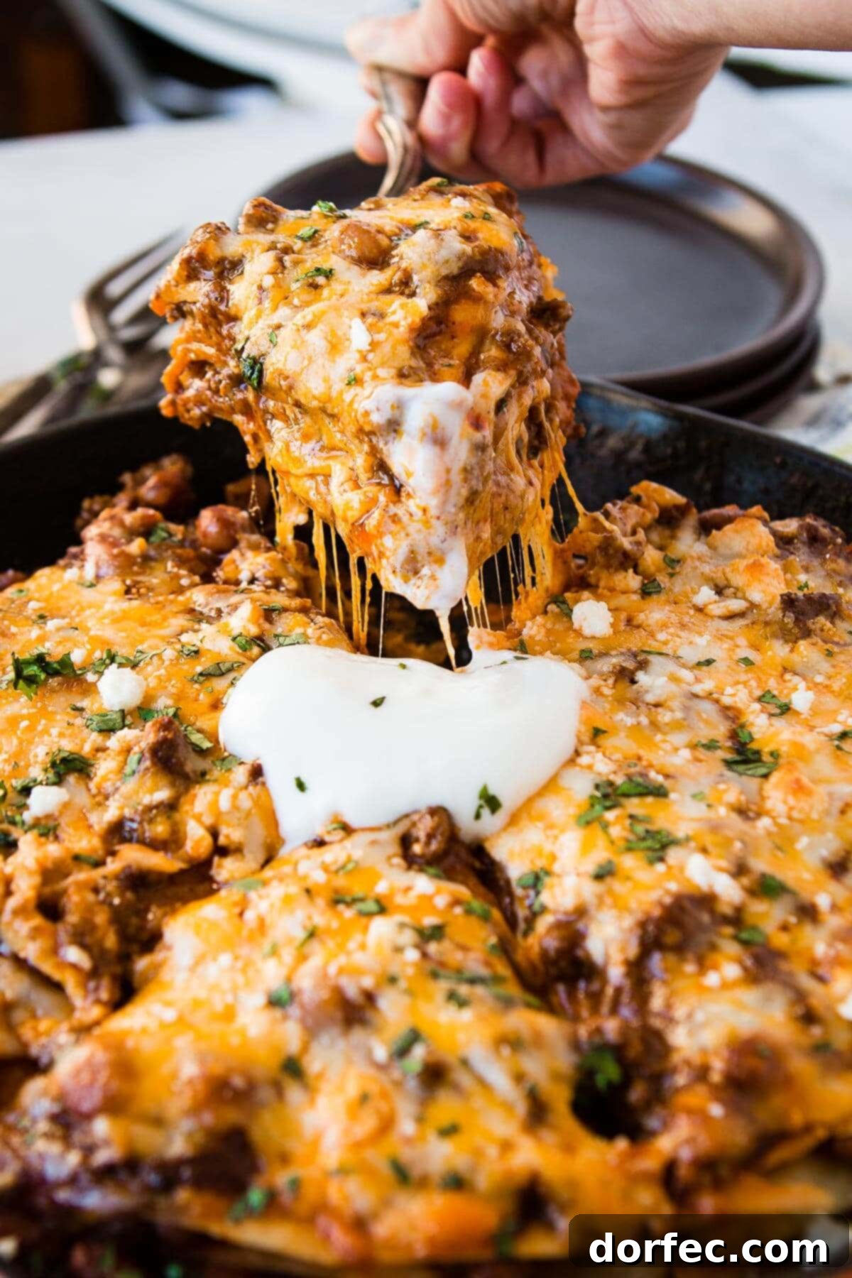 Quick One Skillet Ground Beef Enchilada Dinner 12 Another mouthwatering photo of a slice of ground beef enchilada casserole being carefully removed from a hot cast iron skillet, ready to be enjoyed.