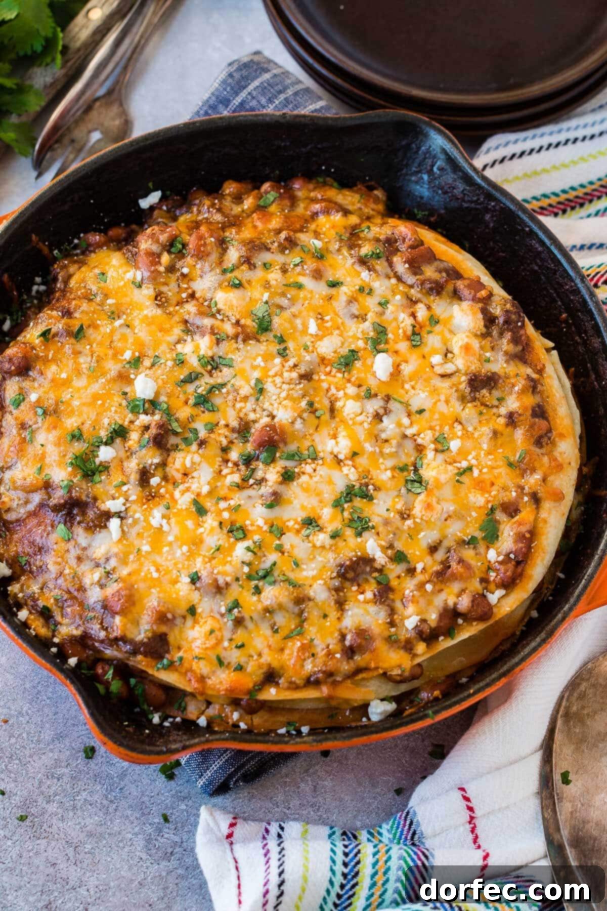 Quick One Skillet Ground Beef Enchilada Dinner 6 An overhead shot of a full ground beef enchilada casserole in a cast iron skillet, showcasing its golden-brown, cheesy top layer.
