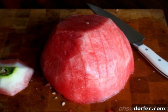 Watermelon being sliced into uniform cubes