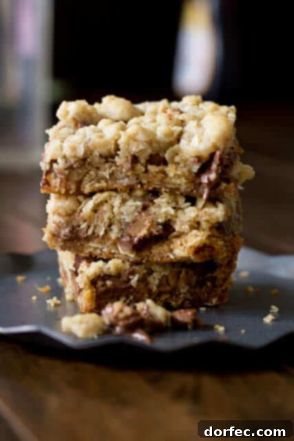 Irresistible Reese's Crumble Bars: Buttery oatmeal crumble base and topping, loaded with chocolate chips and Reese's Peanut Butter Cups.