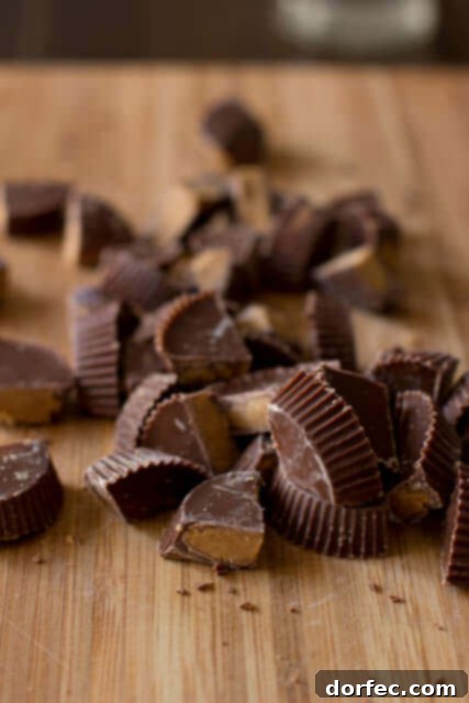 A stack of freshly baked Reese's Crumble Bars, highlighting the generous filling of chocolate and peanut butter cups.