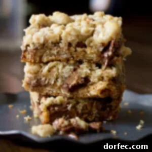 You will fall in love with these #Reeses Crumble bars. Buttery oatmeal cumble stuffed with chocolate chips and #Reesespeanutbuttercups ohsweetbasil.com_