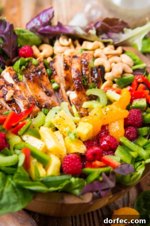 A close-up of the easy teriyaki chicken salad, showcasing the poppy seed dressing drizzled over juicy teriyaki chicken, fresh vegetables, and crunchy cashews.