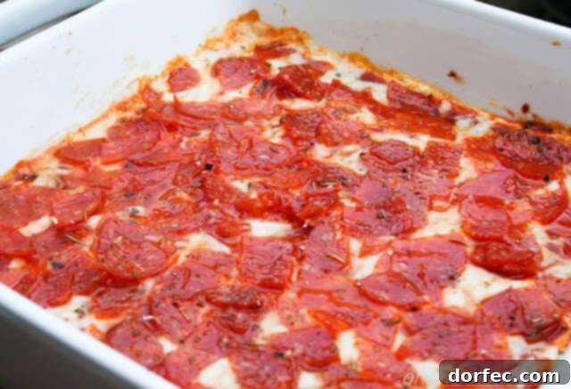 Ultimate Pepperoni Pizza Dip 2 white baking dish filled with bubbling pepperoni pizza dip, ready to serve
