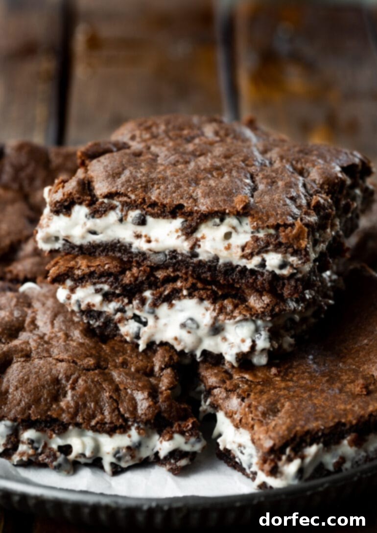 A photo of a few cookies and cream brownies stacked on top of each other, showcasing their fudgy layers and creamy white filling.