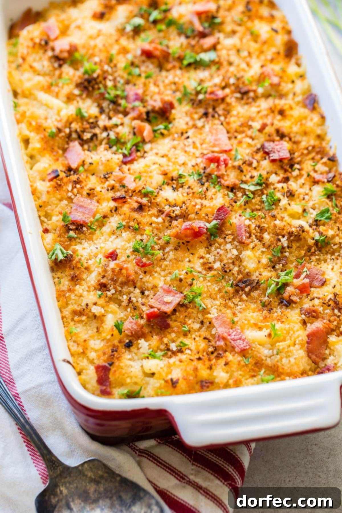 Loaded Chicken Bacon Ranch Macaroni and Cheese 2 Pan of chicken mac and cheese bake on a tea towel, showcasing a golden crispy topping and rich, bubbly cheese