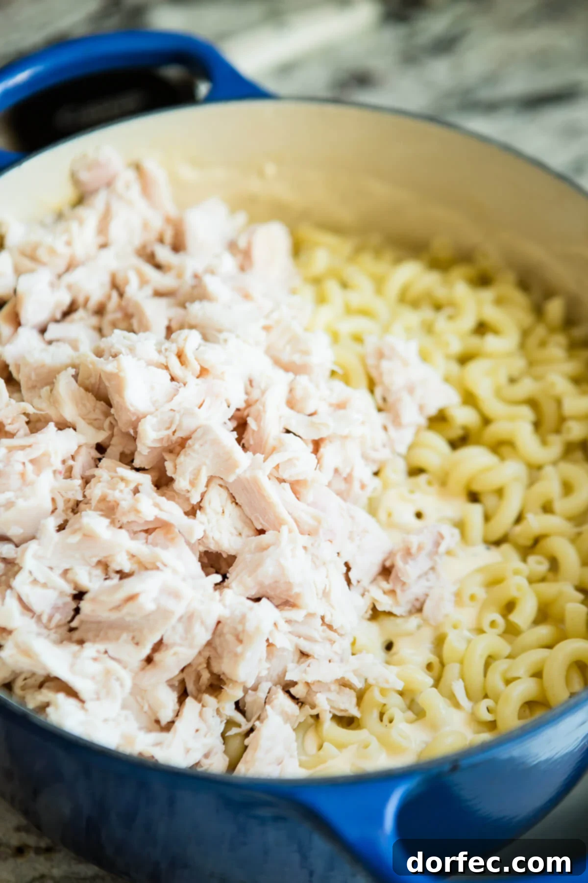 Loaded Chicken Bacon Ranch Macaroni and Cheese 5 Cooked chicken and macaroni noodles coated in a rich cheese sauce in a Dutch oven, ready for baking