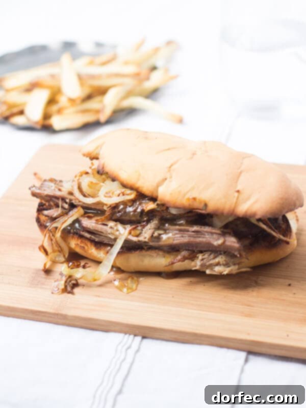 Delicious Pot Roast Sandwich A hearty pot roast sandwich with rich gravy on a cutting board