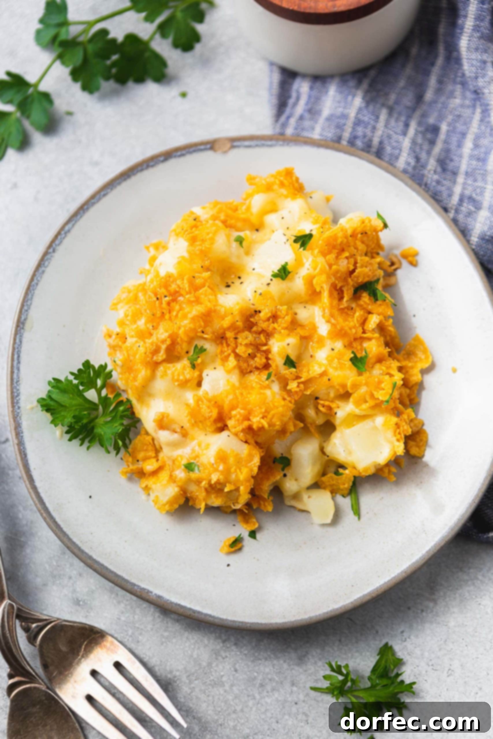 A plate of golden-brown Funeral Potato Casserole with a crispy topping, ready to be served.