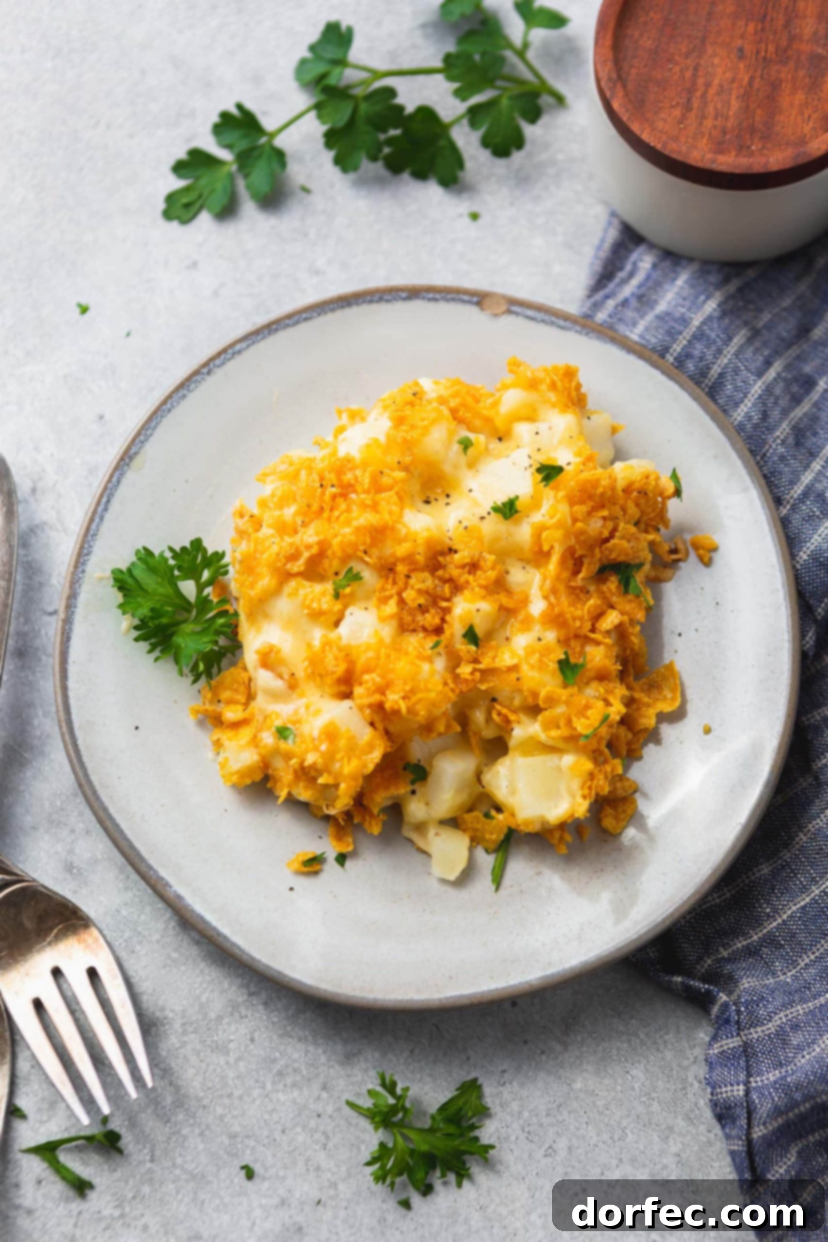 A beautifully plated serving of Funeral Potato Casserole, showcasing its creamy texture and crunchy, golden-brown topping, ready to be enjoyed.
