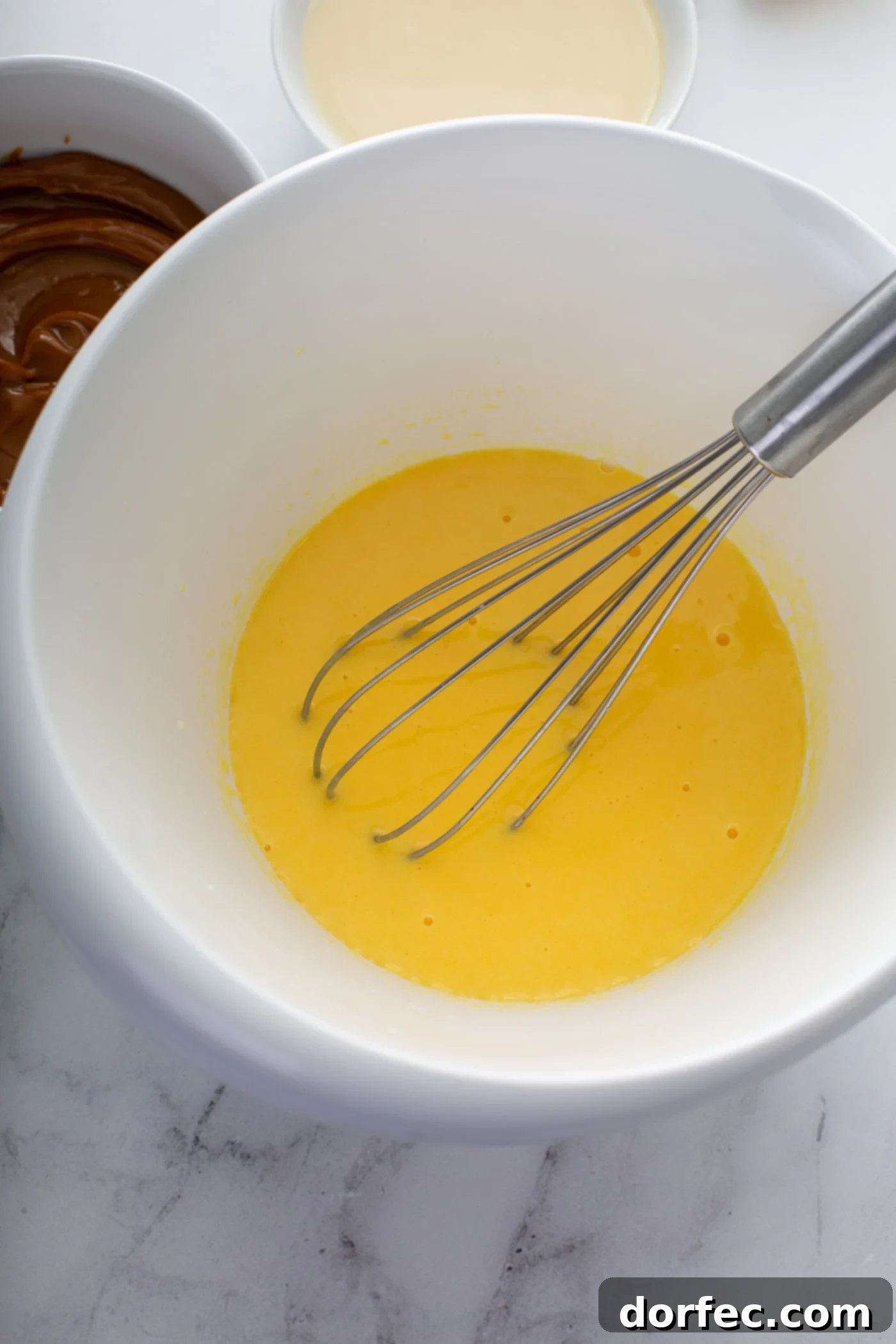Decadent Dulce De Leche Banana Cream Pie 8 A mixing bowl with banana pudding. The pudding is being whisked together.