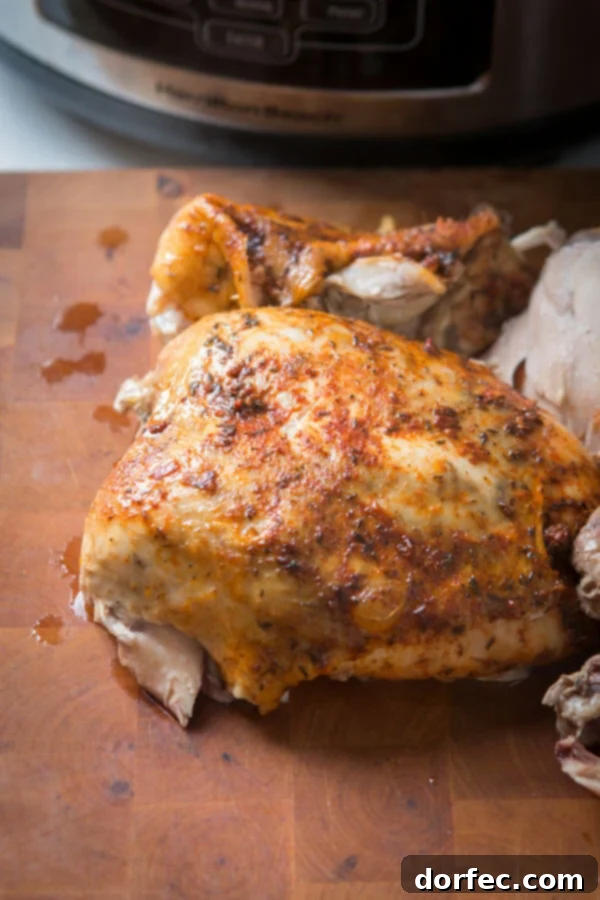 This is the easiest way to enjoy a juicy, rotisserie-like chicken by only using a crockpot. Slow cooker whole chicken that anyone can make! A perfectly cooked, juicy whole chicken resting on a rustic wooden cutting board, ready for carving.