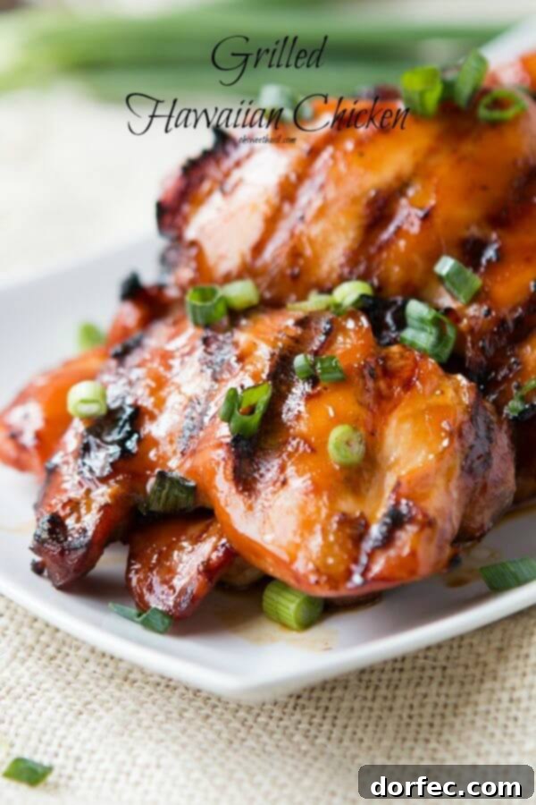 Platter of juicy grilled Hawaiian chicken thighs, garnished with fresh green onions, showcasing their appealing caramelized texture.
