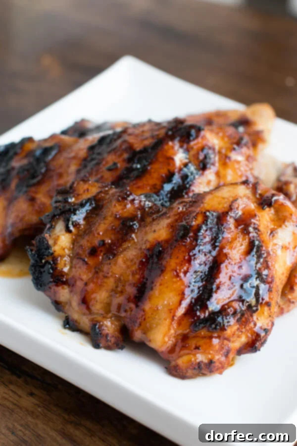Grilled chicken featuring a glossy, sticky honey-lime sauce, garnished with fresh lime slices and herbs, a new family favorite.