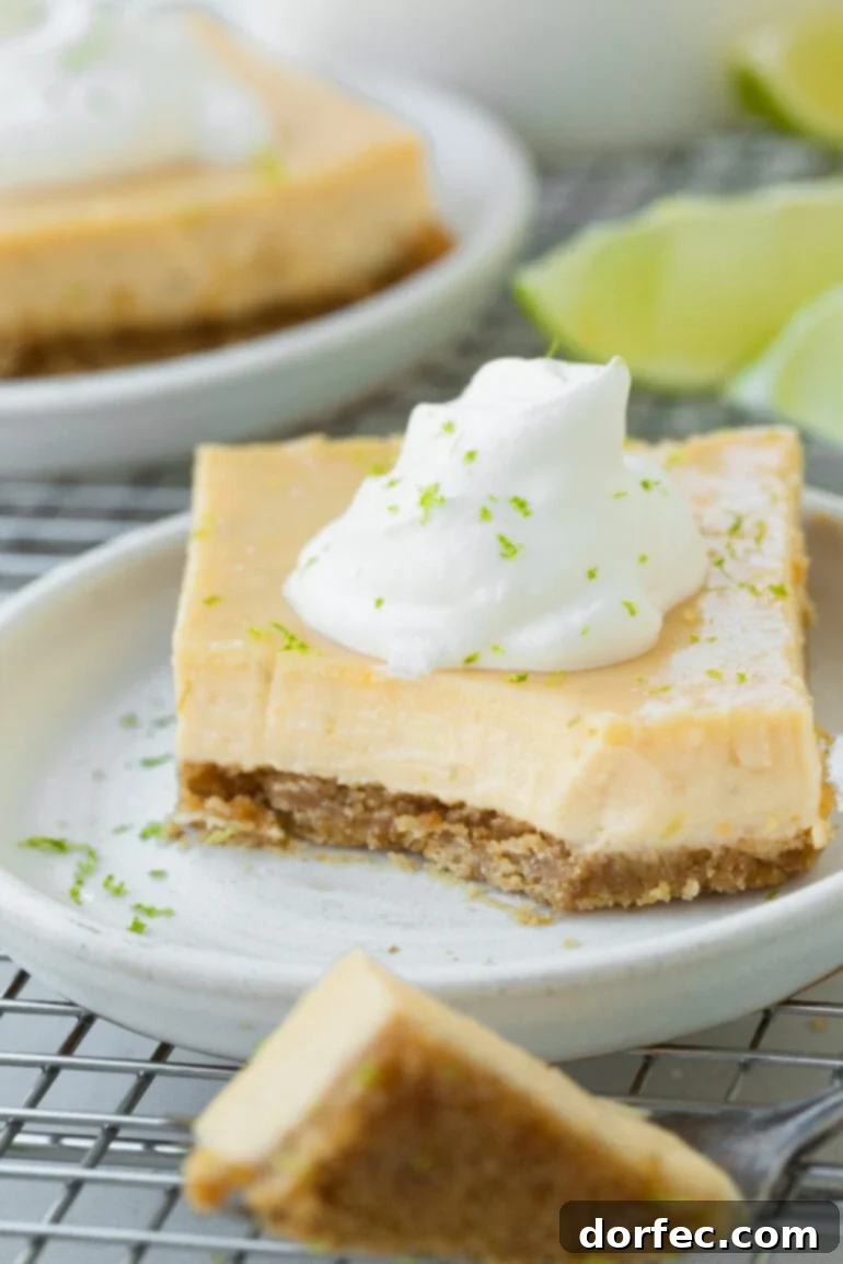 Key Lime Pie Bars 3 A photo of a piece of Torta de Limão on a small dessert plate with a corner of the bar removed and scooped up with a fork.