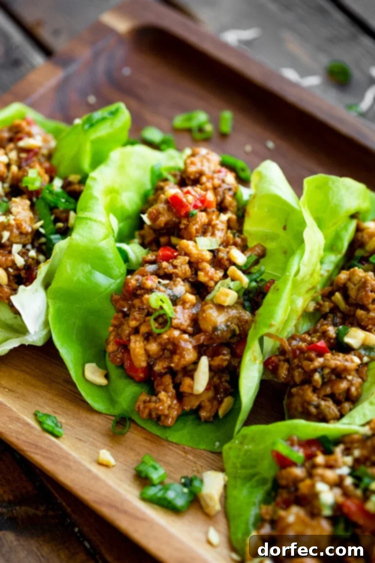 A beautifully presented plate of Thai Peanut Turkey Lettuce Wraps in bright green butter lettuce leaves, ready to be enjoyed.