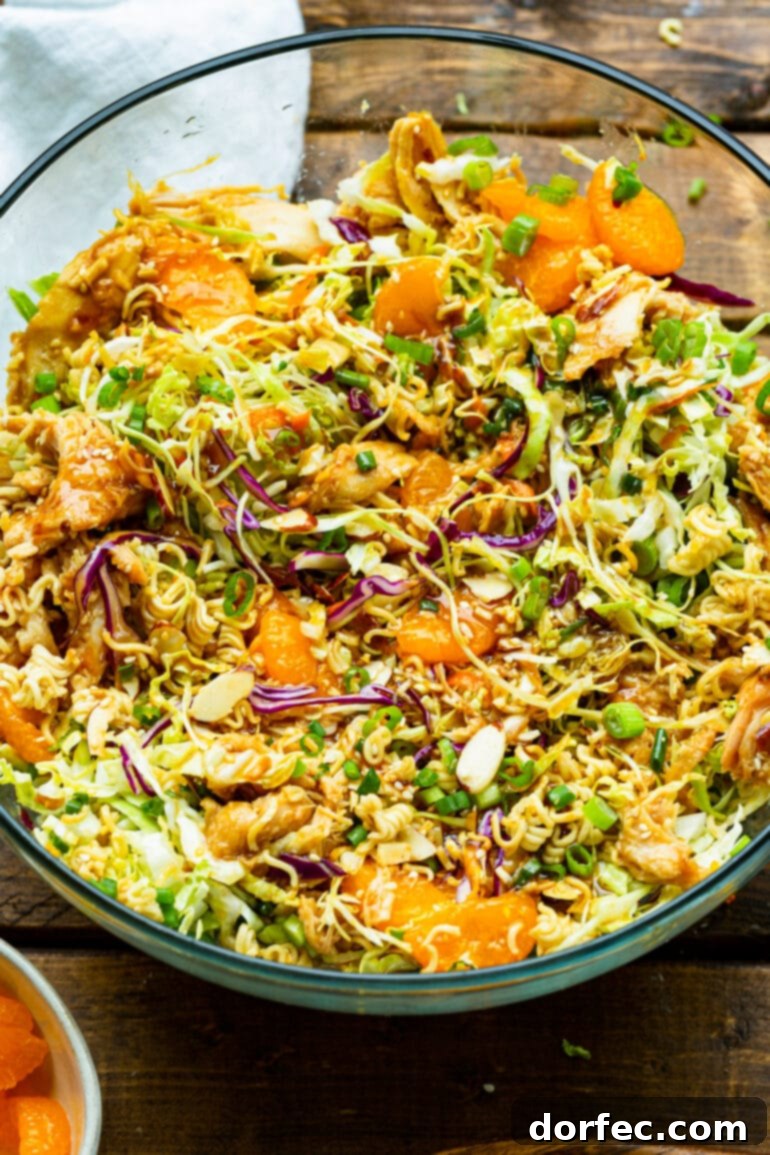 a photo of ramen chinese chicken salad including shredded cabbage, carrots, mandarin oranges, sliced almonds, and crunchy ramen noodles.
