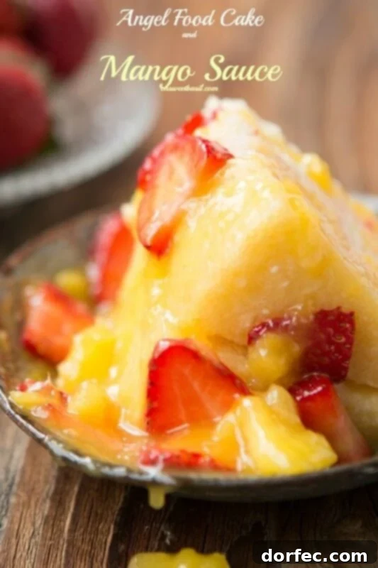 Light and refreshing Angel Food Cake with vibrant Mango Sauce and fresh strawberries, a perfect easy dessert for summer.