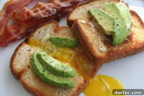 Delicious California Toad in a Hole with perfectly cooked egg, vibrant avocado slices, and a side of crispy bacon