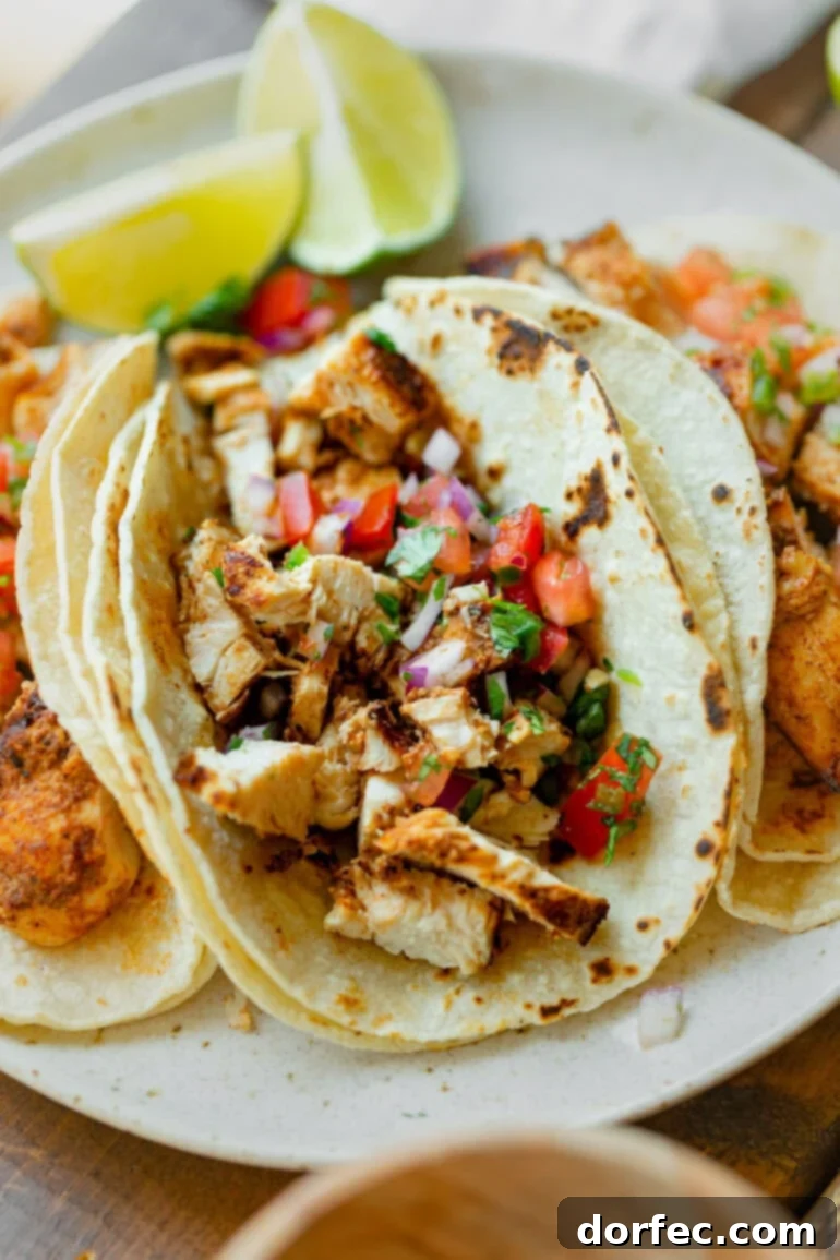 a photo of a grilled chicken taco topped with fresh pico de gallo