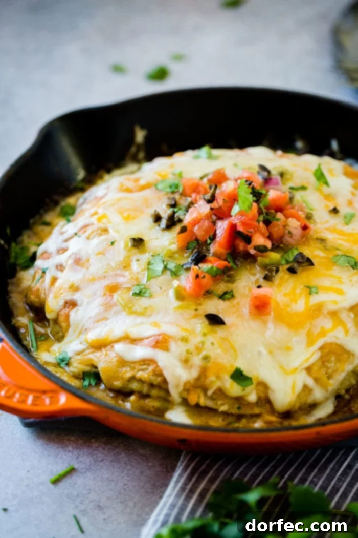 One Pan Honey Lime Chicken Enchilada Bake 3 Close-up of bubbling One Skillet Honey Lime Chicken Enchiladas Casserole, showcasing golden cheese and the delicious layers.