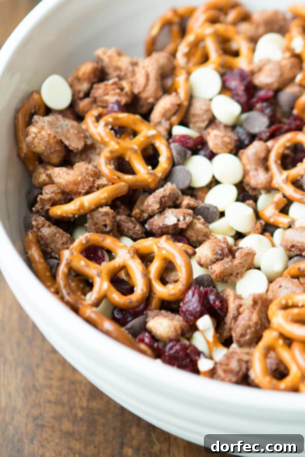 A close-up of a bowl overflowing with the delicious Candied Nuts Snack Mix, inviting guests to grab a handful.