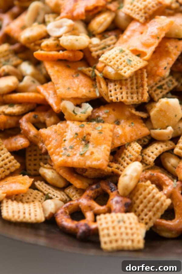 A hearty bowl of Ranch Slow Cooker Chex Mix, filled with savory, seasoned cereal and pretzels, ideal for a party spread.