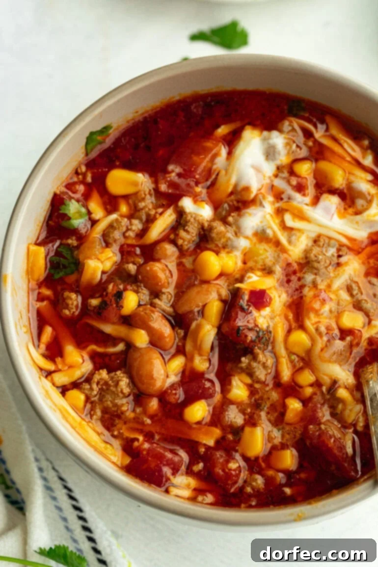 instant pot taco soup in grey bowl topped with cilantro, cheese, and sour cream