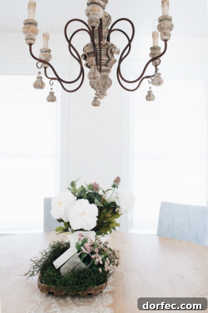 A grand Imperial Castle chandelier from Lighting Connection, perfect for a farmhouse or French Country dining room, featuring white and natural elements.