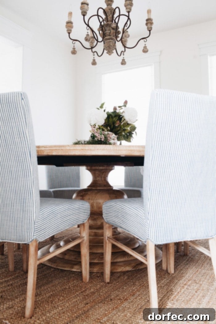 The Monroe Dining Table, a perfect round pedestal table, anchors this French Country dining room, promoting conversation and togetherness.