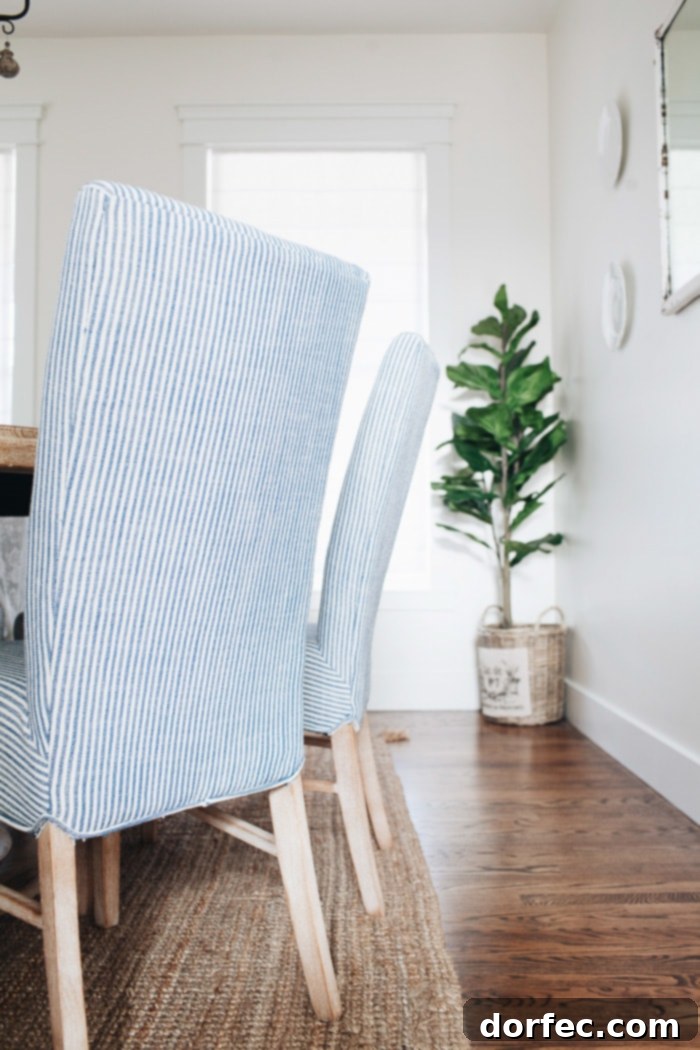 Elegant blue and white striped upholstered Monson chairs with sturdy wood legs, perfectly complementing a French Country dining room.
