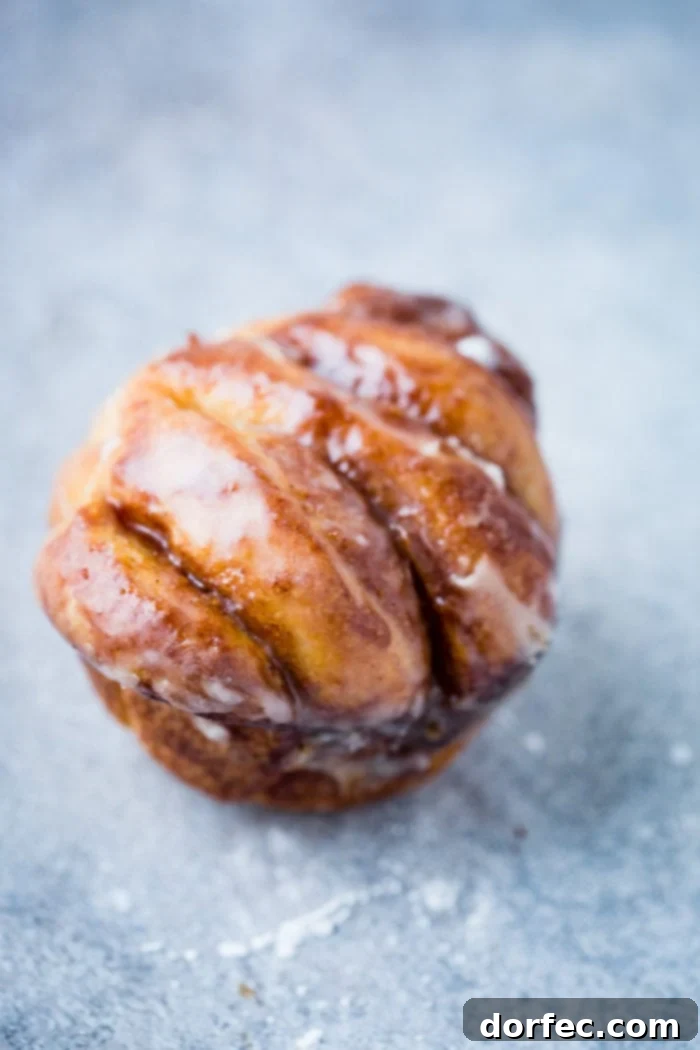 Pillowy Maple Glazed Cinnamon Butterflake Rolls 3 A single butterflake roll with a light maple glaze