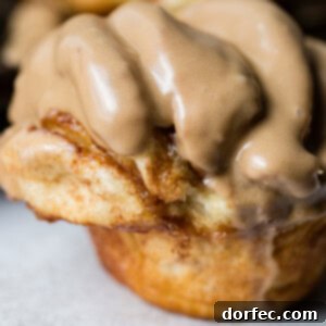 Pillowy Maple Glazed Cinnamon Butterflake Rolls 6 A close up of a cinnamon butterflake roll with maple glaze