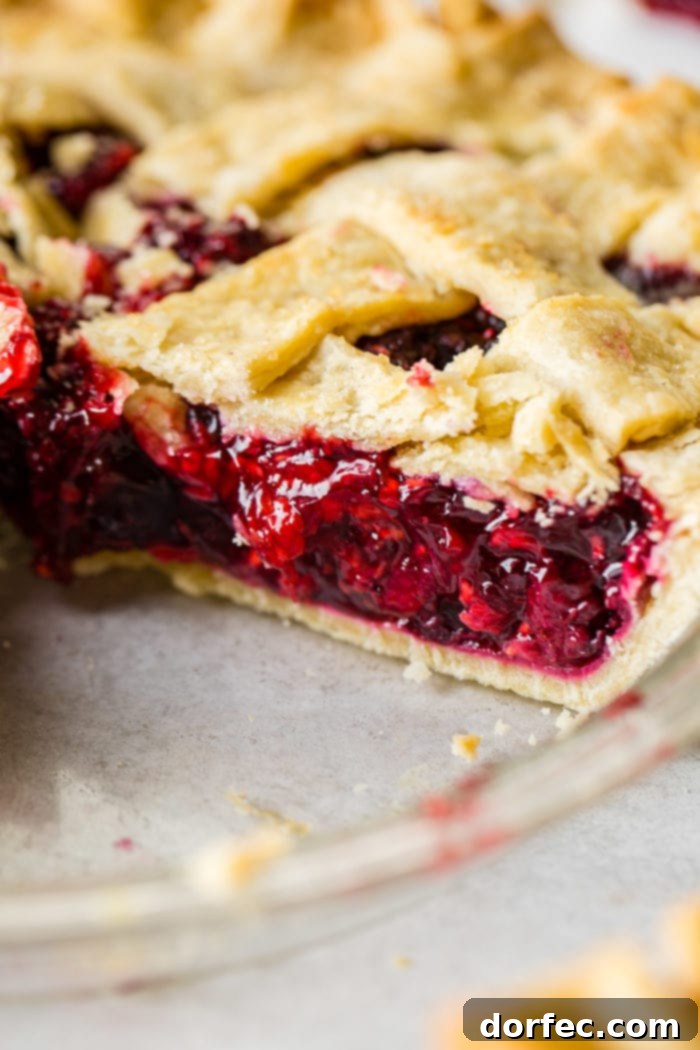 Ultimate Razzleberry Pie 3 Close-up of vibrant raspberries, blueberries, and blackberries, key ingredients for razzleberry pie.