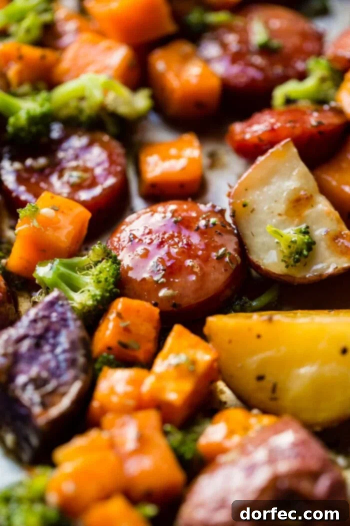 Delicious roasted sliced kielbasa and tender root vegetables on a sheet pan, drizzled with honey garlic sauce