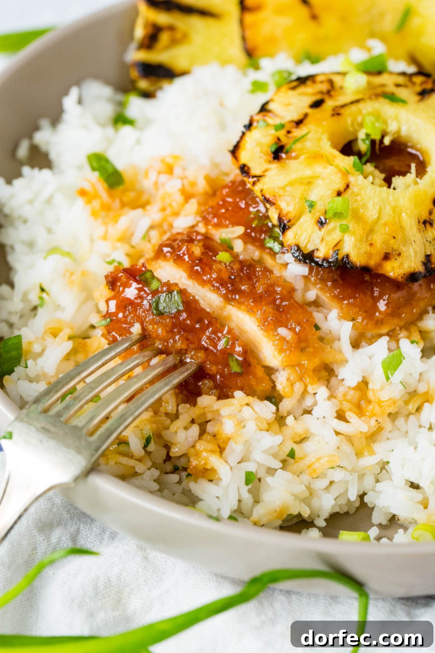 Sweet and Sticky Pineapple Chicken Dinner 7 A delightful serving of breaded sticky sweet and sour chicken over white rice, crowned with a grilled pineapple slice, ready to be savored. This dish is perfect for freezing the sauce for later use!