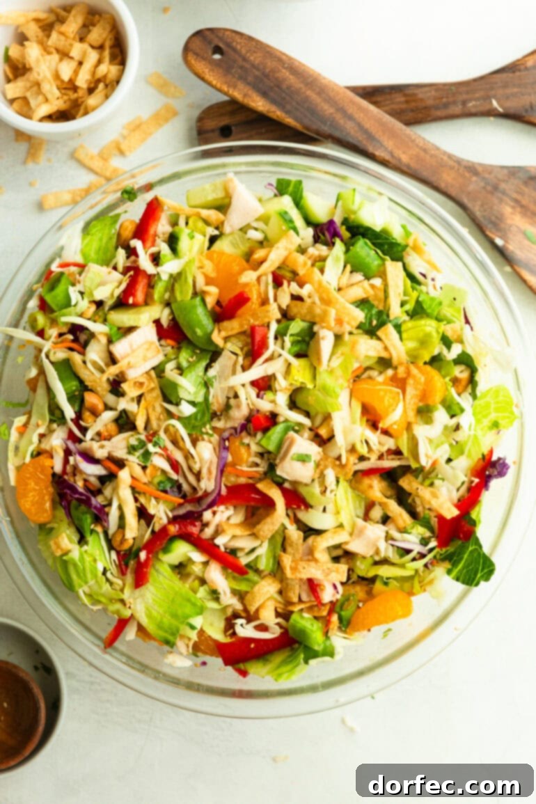 Another enticing view of a large glass bowl filled with Wonton Chinese Chicken Salad, showcasing the abundant mix of ingredients and crispy wonton toppers.