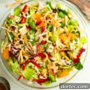 a large glass bowl full of chinese chicken salad with wontons