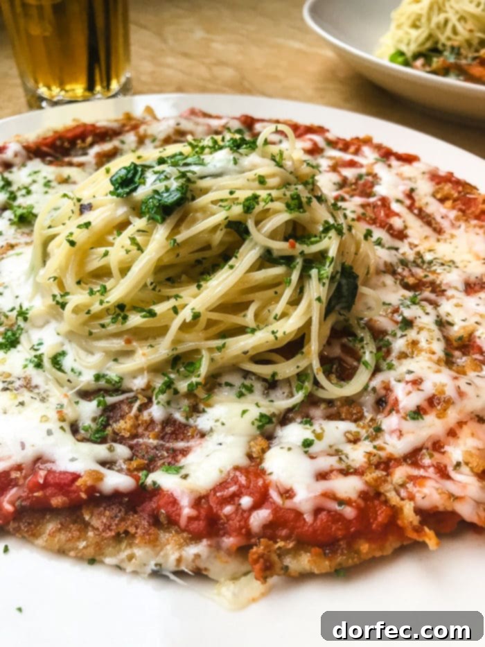 A close-up of the unique Chicken Parmesan Pizza at The Cheesecake Factory, featuring a chicken-based crust and savory toppings.
