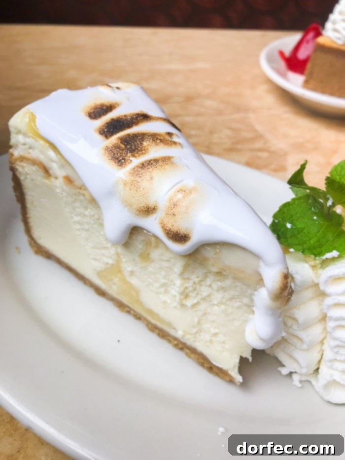A slice of Lemon Meringue Cheesecake, showcasing its zesty filling and delicate meringue topping, a bright and refreshing dessert.