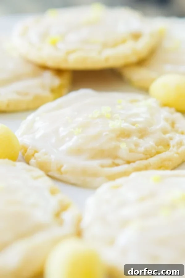 Close-up of a soft and chewy lemon drop cookie, showing the glazed top and crushed lemon drops. ohsweetbasil.com